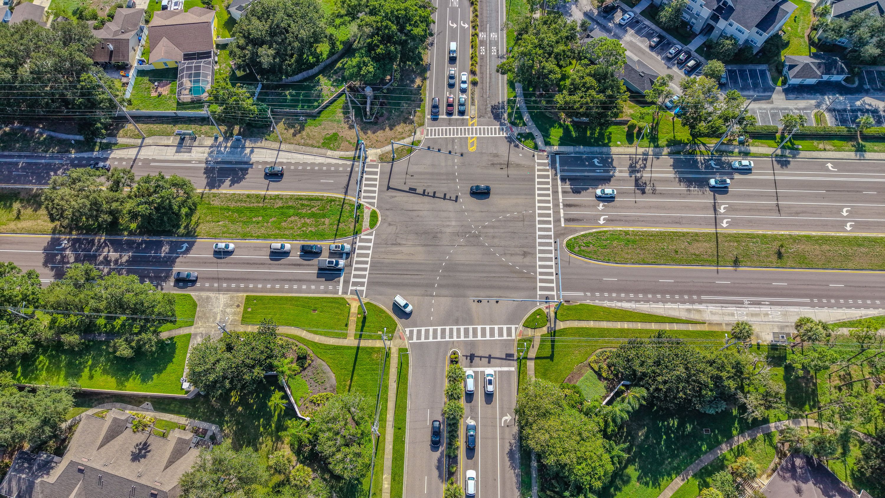 High-angle aerial view of a busy intersection in Tampa, Florida, showcasing suburban traffic patterns and greenery.