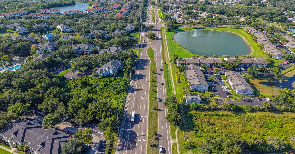 A stunning aerial view of a suburban neighborhood, revealing lush greenery and residential buildings in Florida.