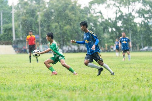 Free Players in a rainy soccer match demonstrating determination and teamwork. Stock Photo
