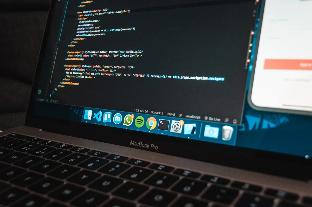 A laptop screen glowing with program code on a desk late at night