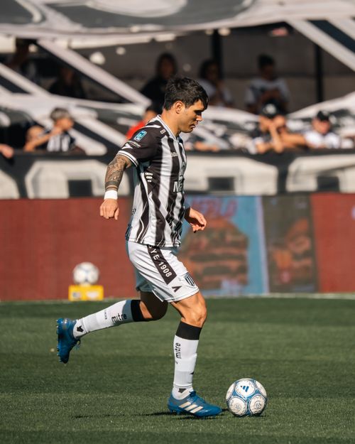 Free A soccer player dribbles the ball on a sunny day during a match. Stock Photo