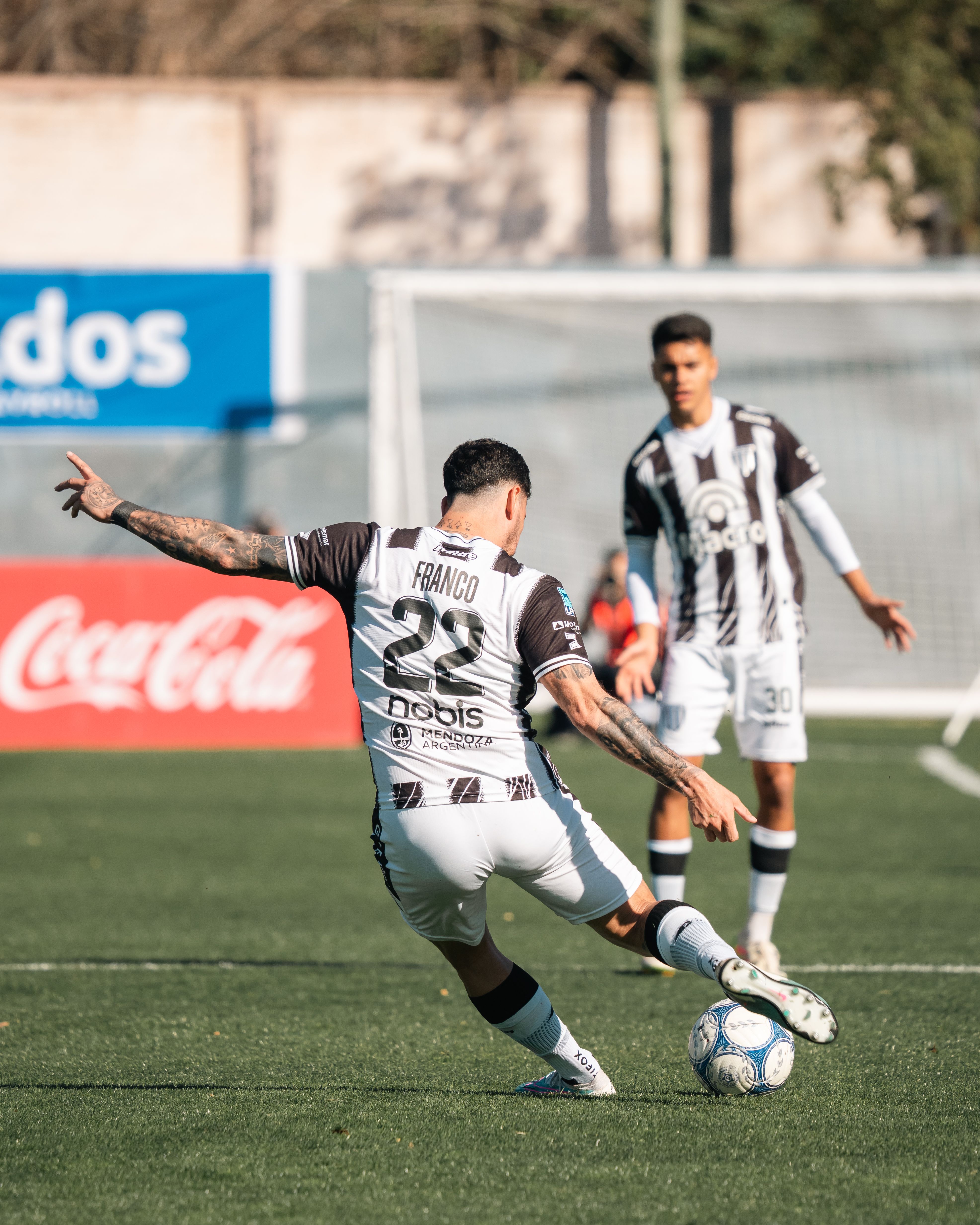 Player Franco in action during a soccer match on a bright day.