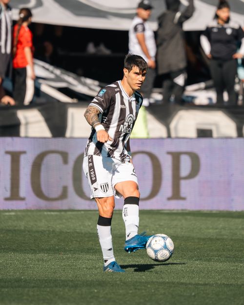 Free Professional soccer player in black and white kit poised to kick a ball during a daytime match. Stock Photo