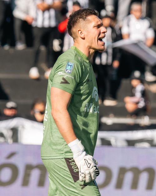 Free A football goalkeeper in green attire passionately shouts on the field. Stock Photo