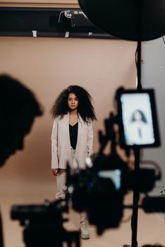 Young model with afro hair during a stylish studio photoshoot.