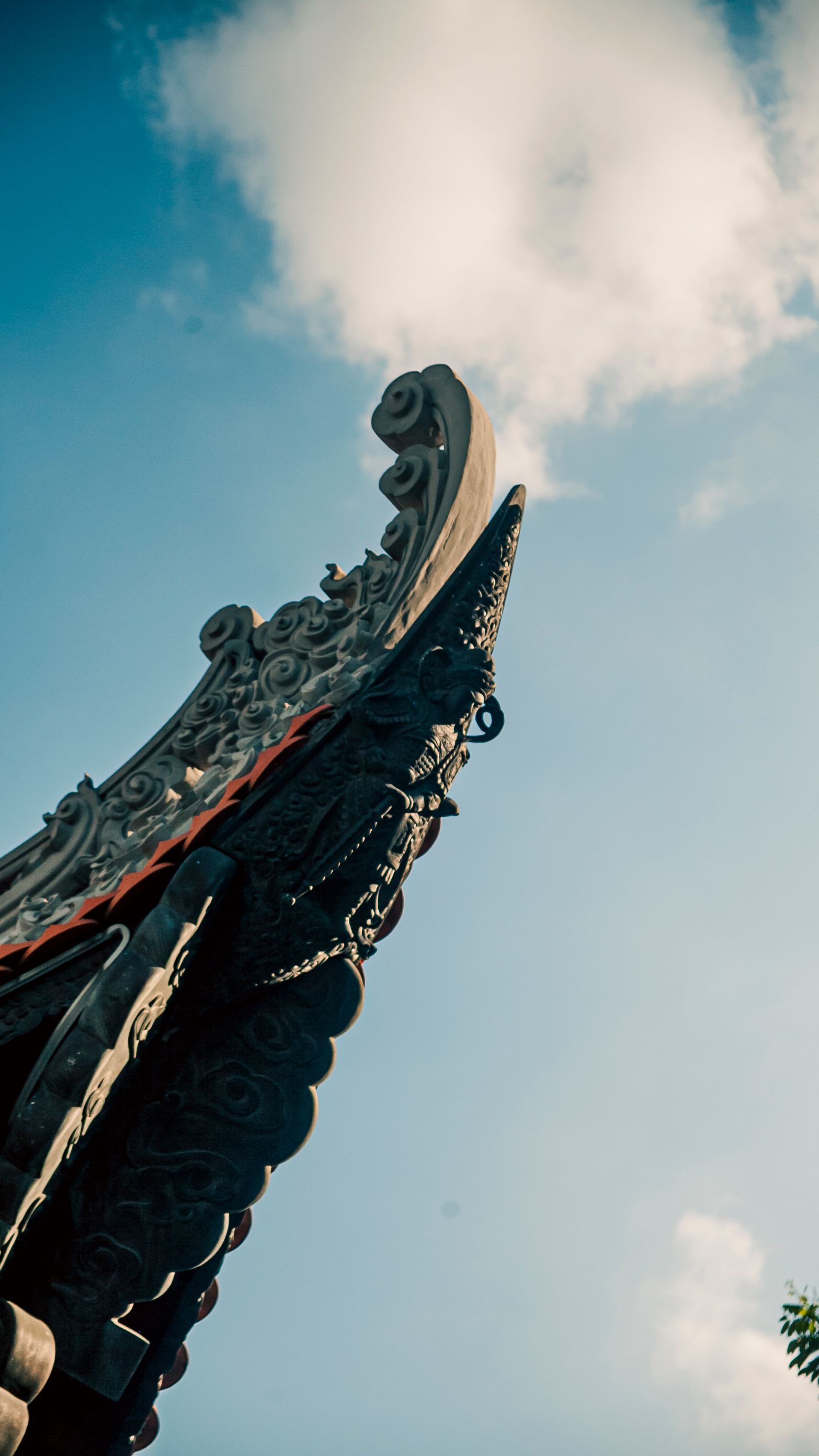 Stunning view of an ornate temple roof against a clear blue sky in Ho Chi Minh City, Vietnam.