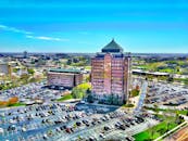 从晴朗的蓝天下鸟瞰奥弗兰公园的现代摩天大楼和停车场