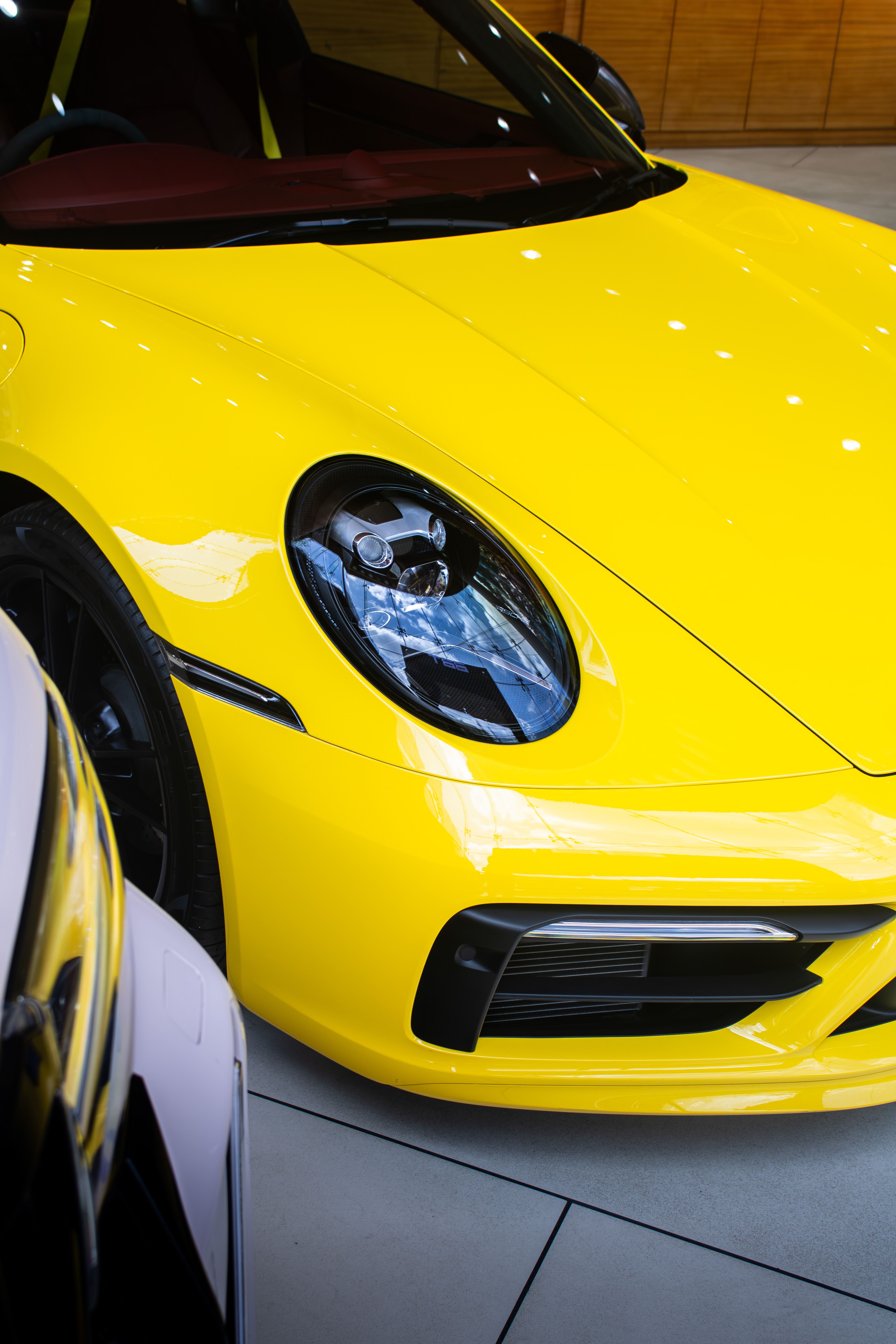 Stylish yellow Porsche 911 Carrera captured in a Bengaluru showroom, highlighting luxury automotive design.