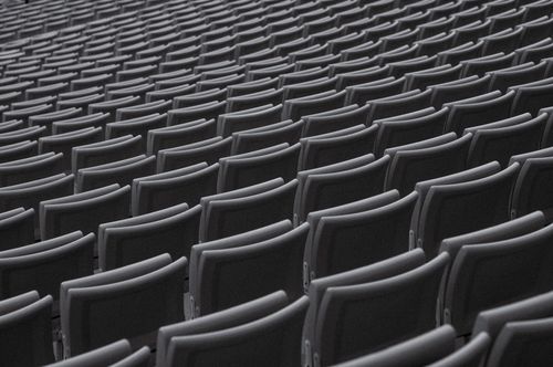 Free A captivating view of endless rows of grey chairs in an empty auditorium. Stock Photo