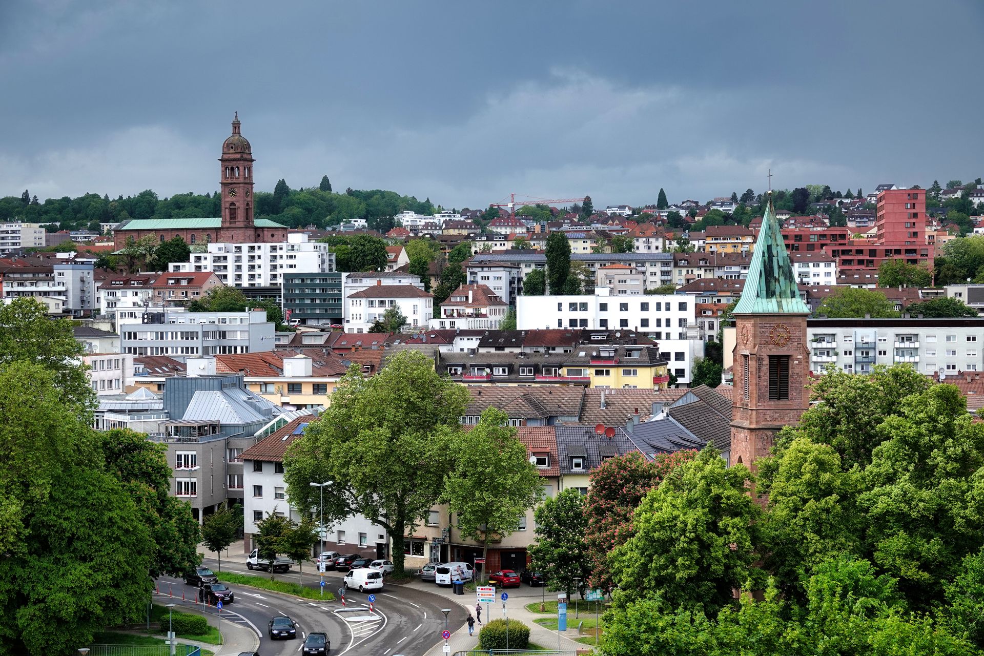 Aerial view of Pforzheim with historical landmarks and lush greenery under cloudy skies.