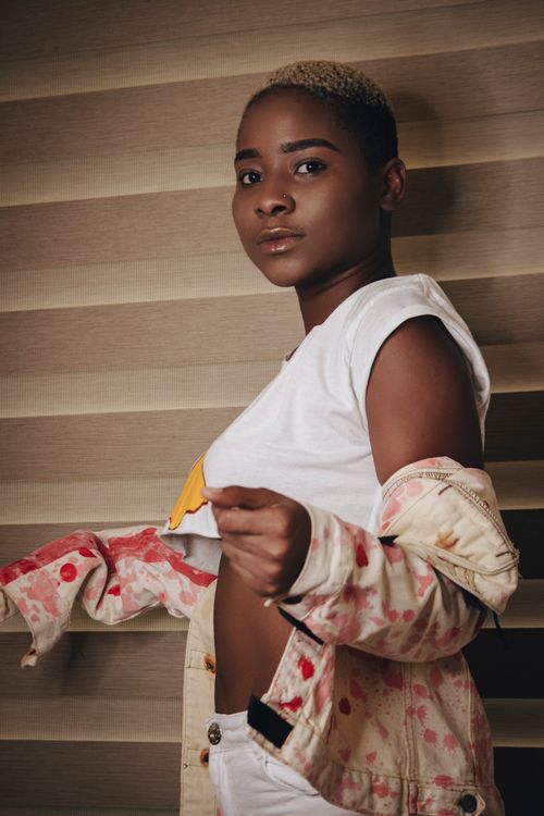 Free Portrait of a young Black woman wearing a floral jacket and crop top, exuding confidence. Stock Photo
