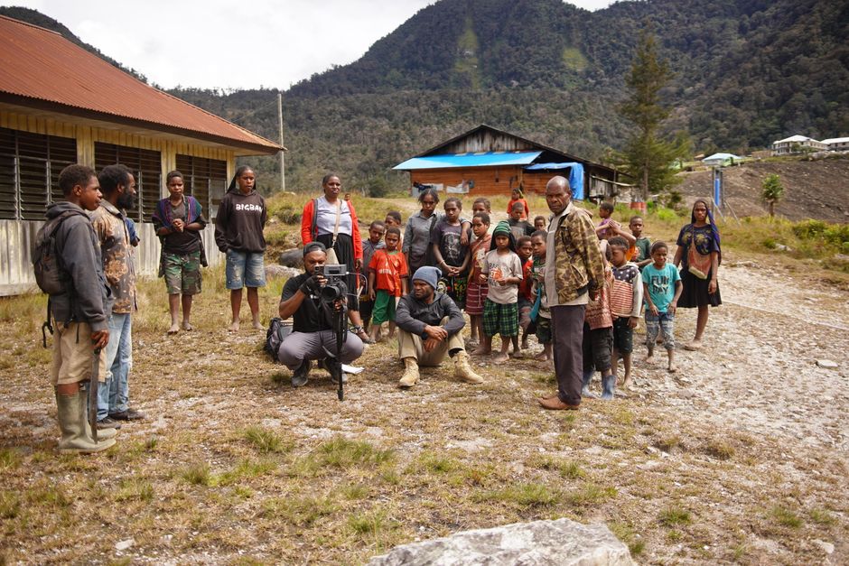 Fotomural Un grupo diverso de personas posa al aire libre en un entorno rural de montaña, mostrando la cultura y el sentido de comunidad.