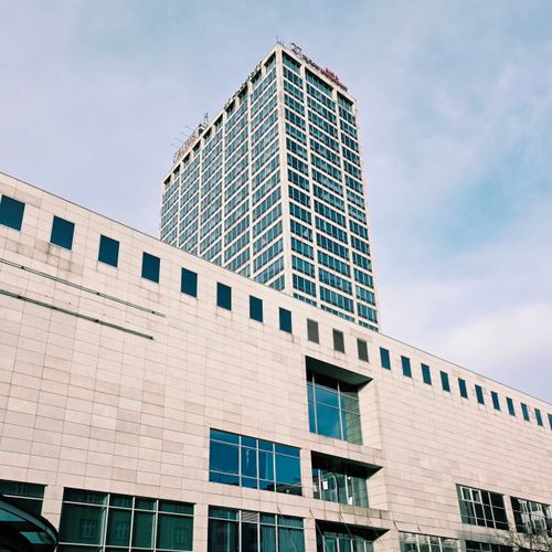 Free View of a modern high-rise building against a clear blue sky, ideal for architectural or urban themes. Stock Photo