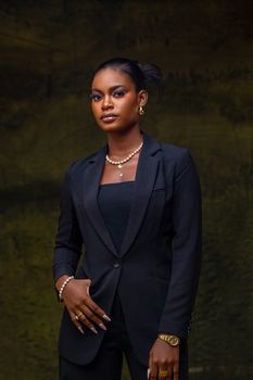 Portrait of a confident woman in a stylish black suit with jewelry.