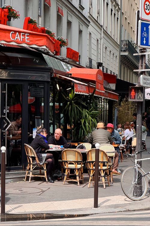 Free Outdoor seating at a traditional Parisian café, capturing local ambiance and charm. Stock Photo
