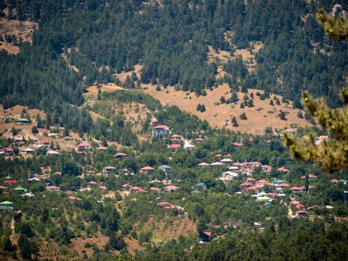 Free A peaceful village nestled in the mountains with lush greenery and rustic houses. Stock Photo