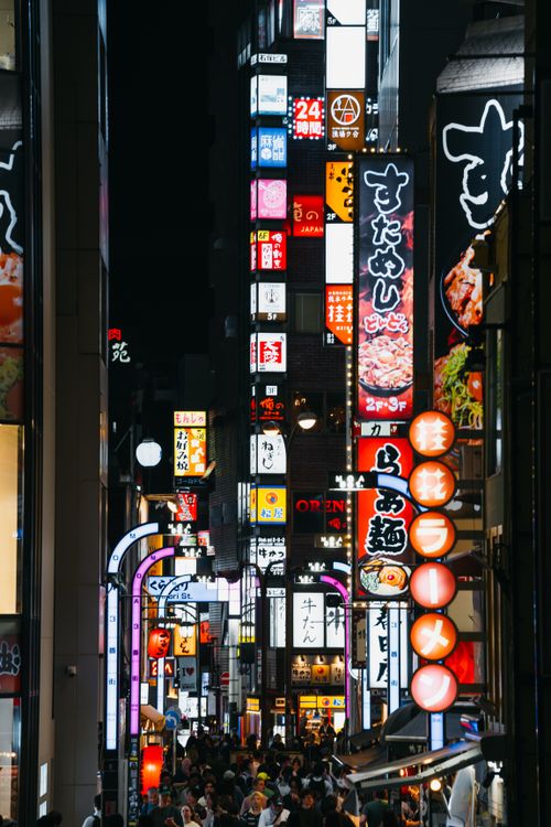 Free A bustling view of Tokyo's Shinjuku at night, full of neon lights and people. Stock Photo