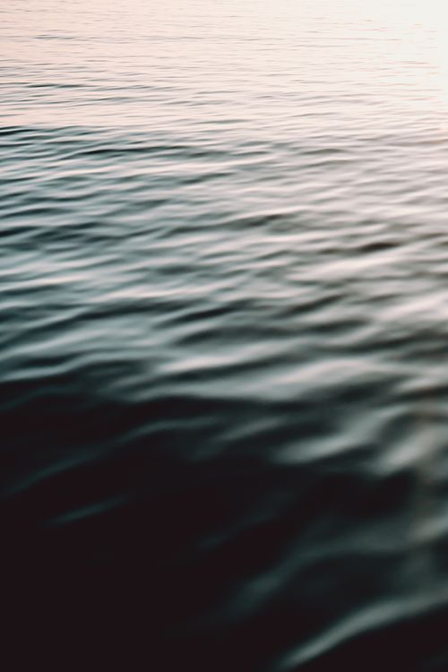Free Gentle ripples on the sea captured at sunset, creating a calming and serene atmosphere. Stock Photo