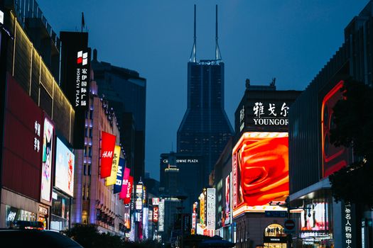 Shanghai cityscape with glowing neon signs and skyscrapers in the background.