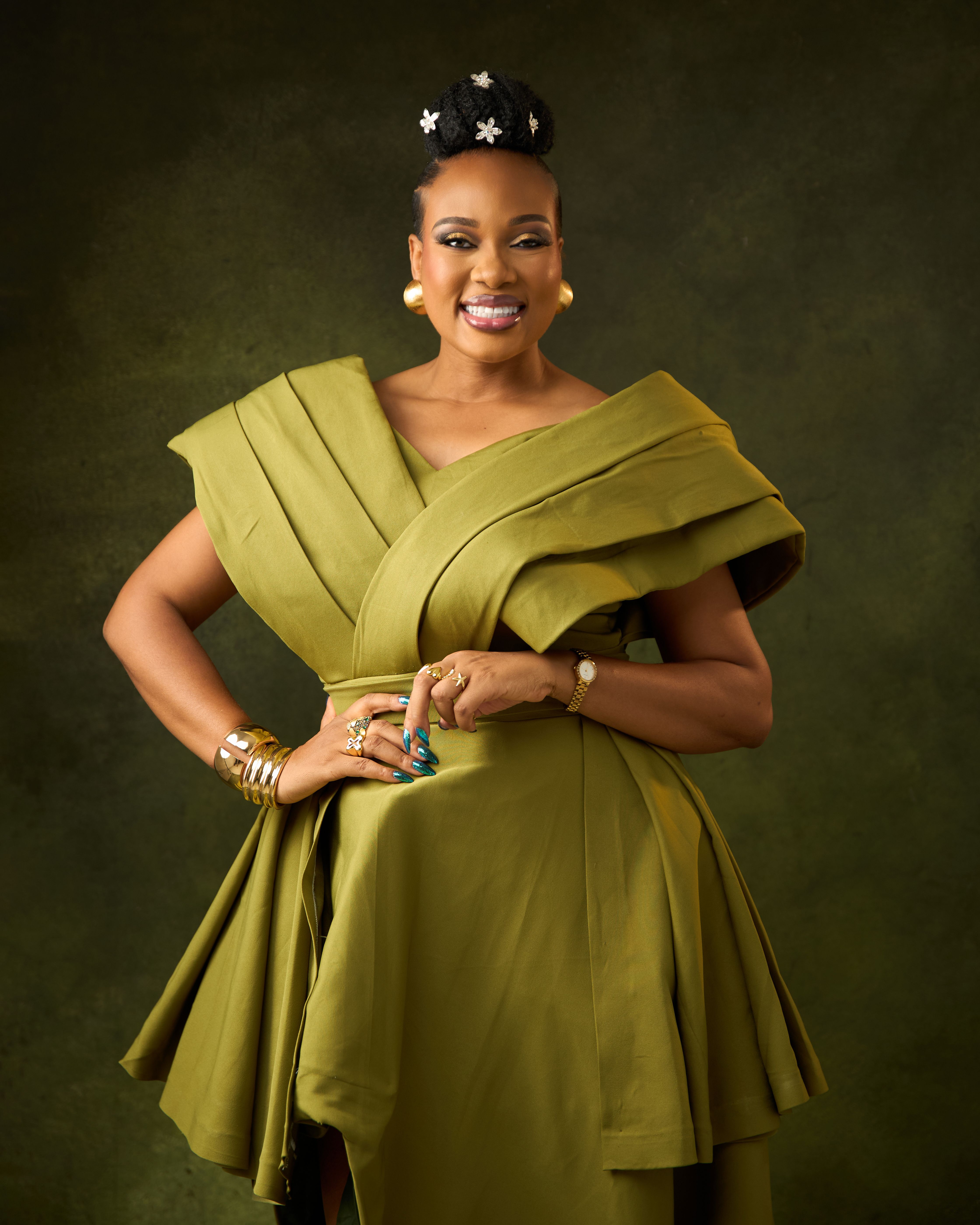 Portrait of a smiling woman in an elegant green dress with star accessories in her hair.