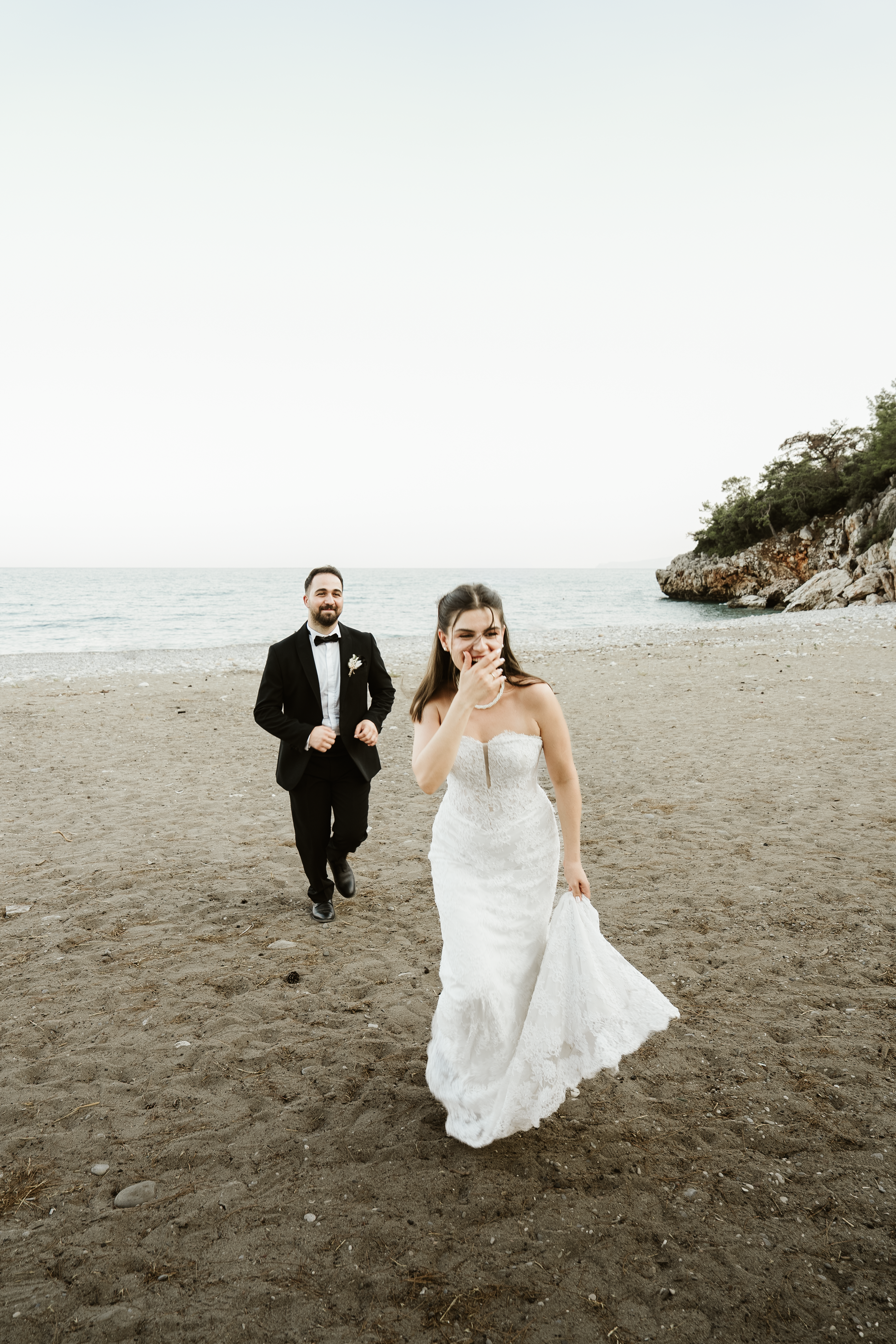 Elegant wedding couple on a sandy beach in Antalya, capturing a romantic moment by the sea.