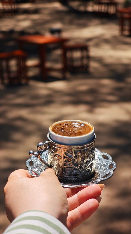 Free Enjoy a rich Turkish coffee served in an ornate cup with an outdoor ambiance. Stock Photo