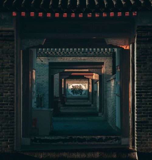 Free Dark brick corridor with artistic arches and dramatic light play. Stock Photo