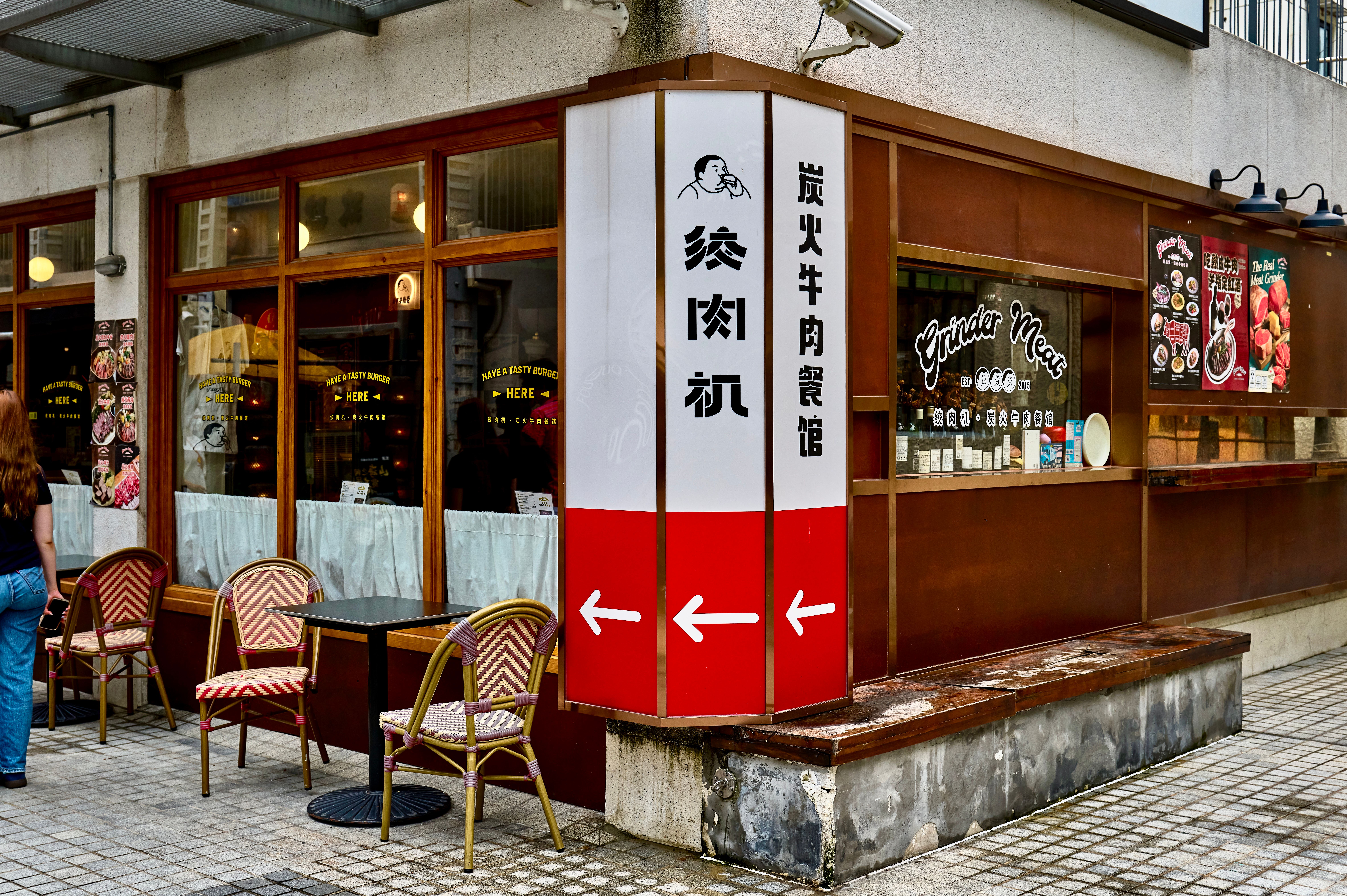 Charming sidewalk view of a Shanghai restaurant with outdoor seating and signage, encapsulating urban dining.