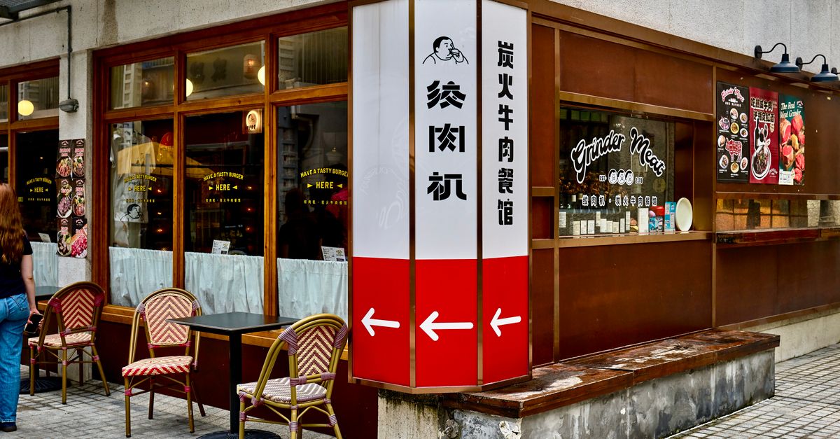Charming sidewalk view of a Shanghai restaurant with outdoor seating and signage, encapsulating urban dining.