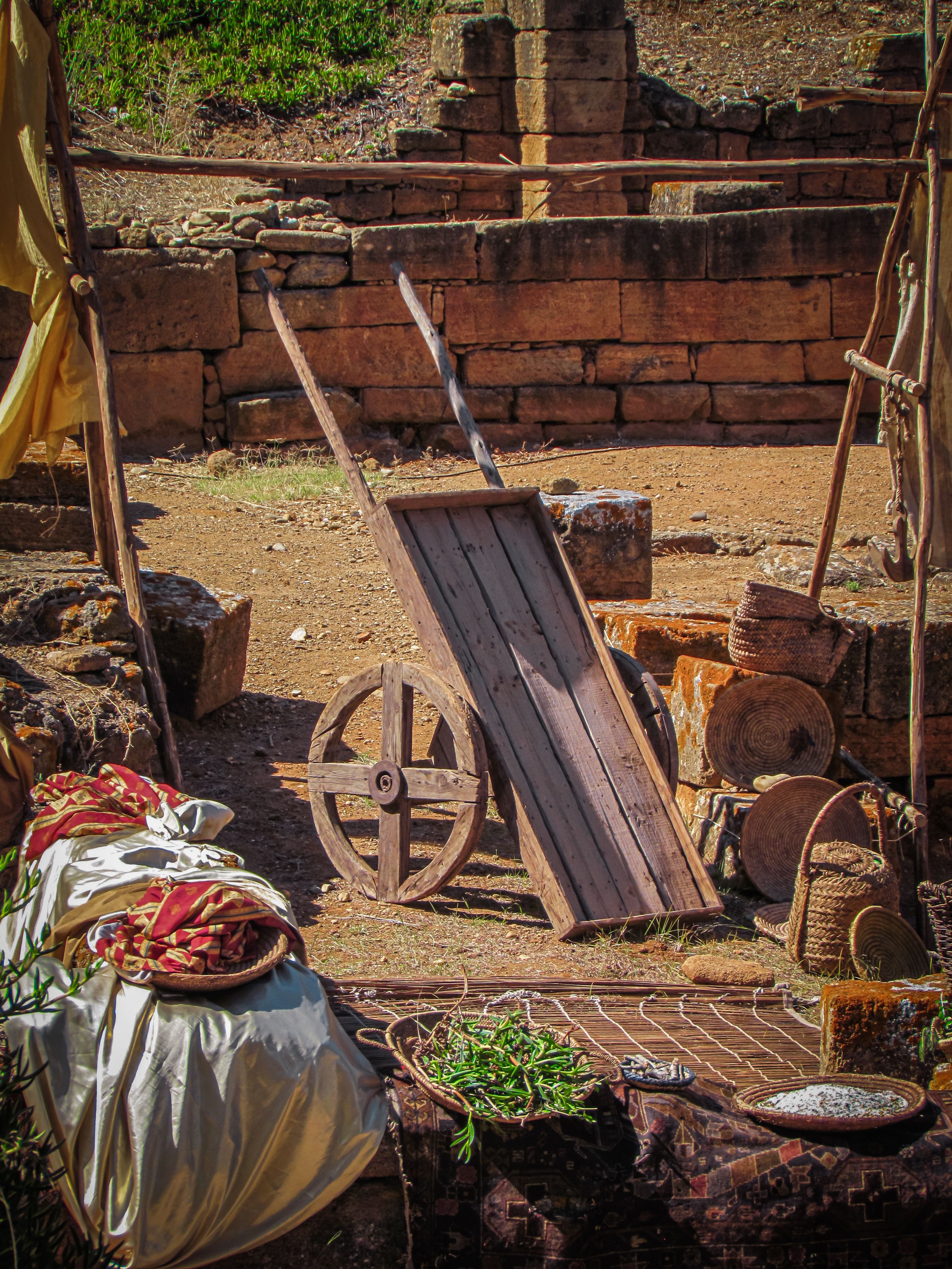 An authentic depiction of a rustic market scene with wooden cart and ancient stone walls in Rabat, Morocco.