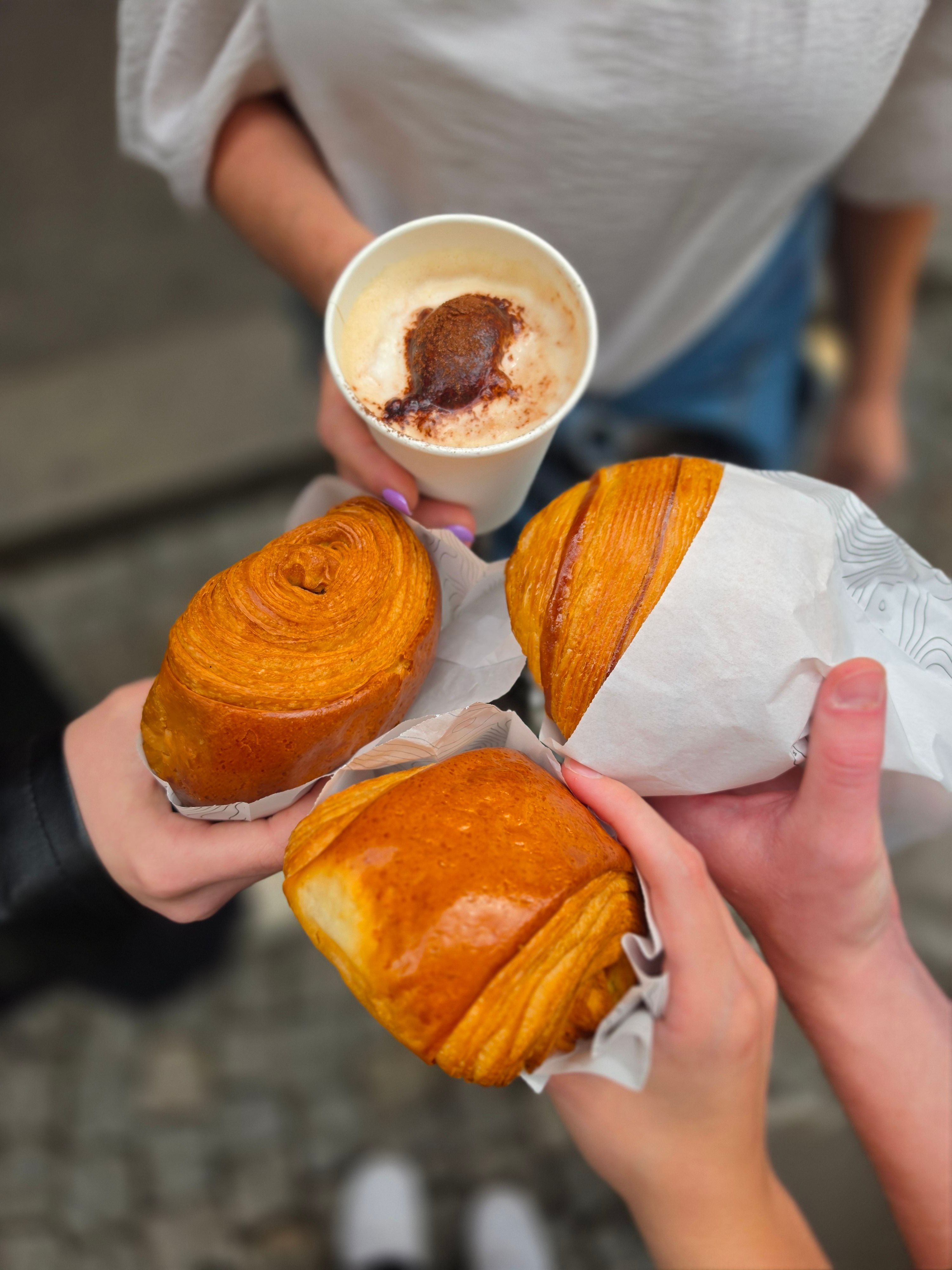 Three people enjoying a morning coffee and pastries in Paris, France.