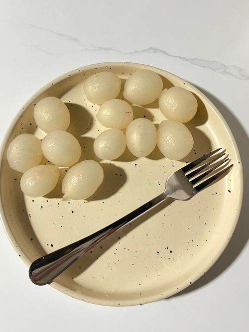 Free Top view of fresh peeled lychees on a speckled plate with a fork, highlighting simplicity and freshness. Stock Photo