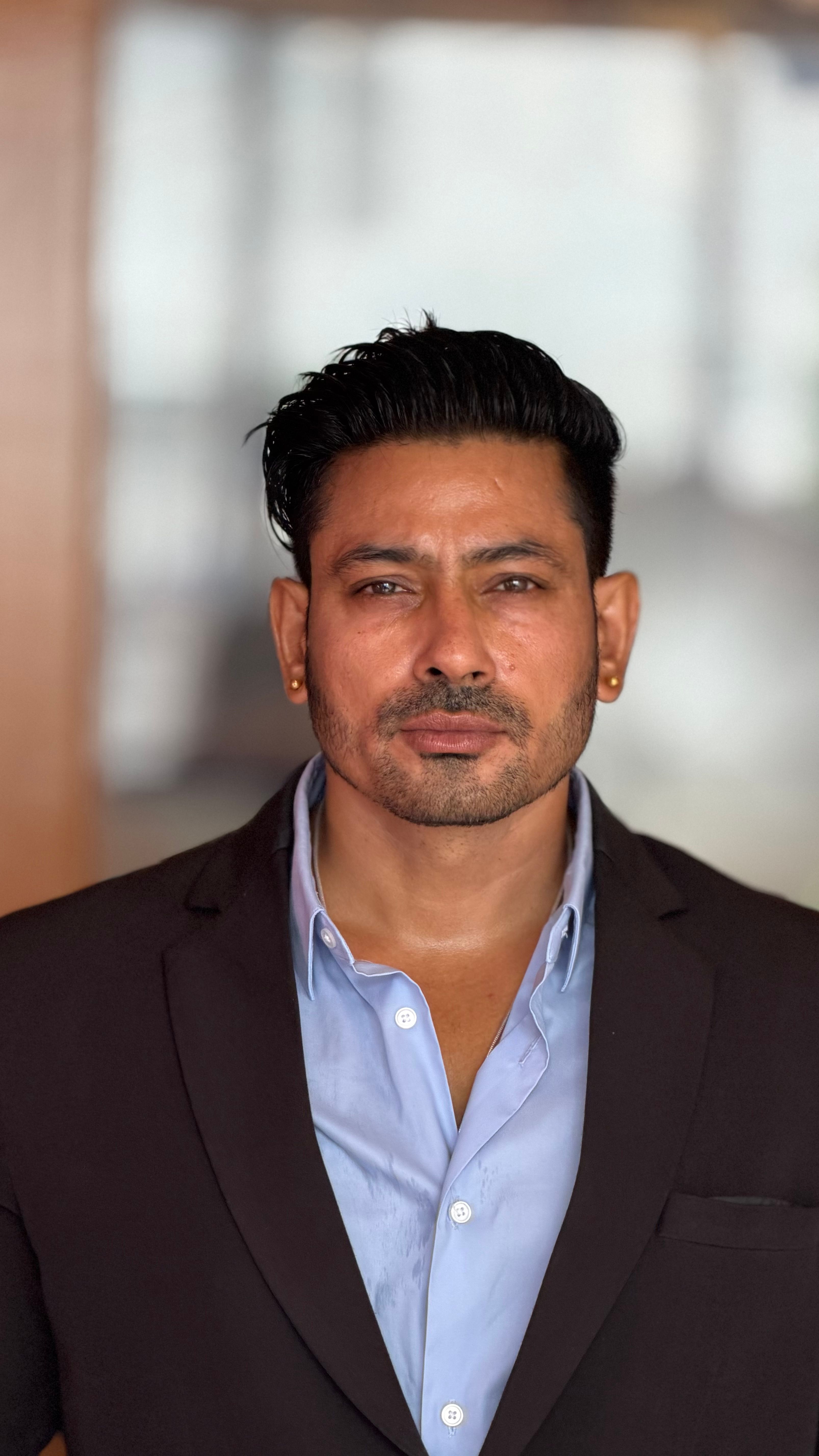 Portrait of a confident businessman in a suit with blurred background, showcasing professionalism.