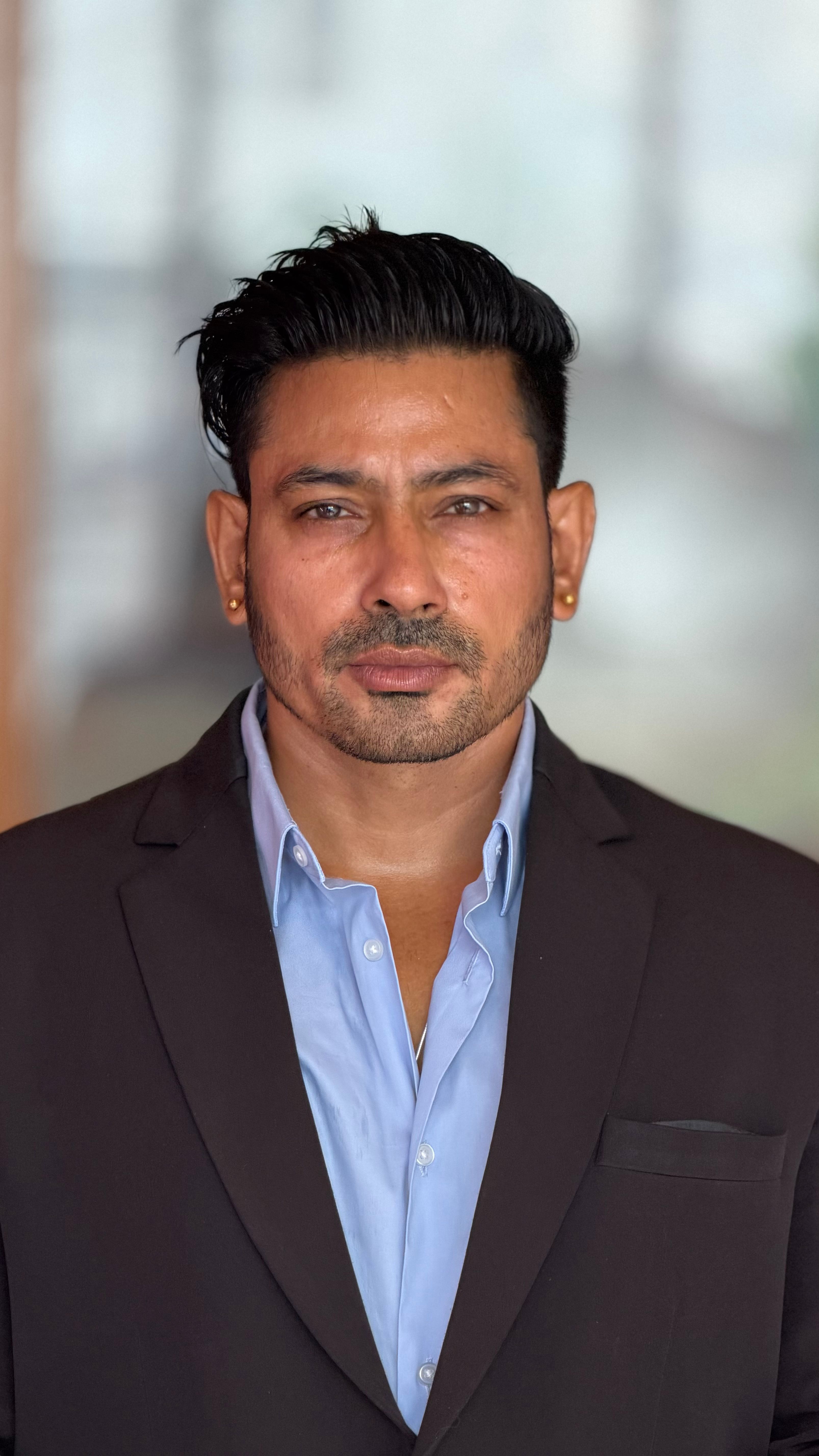 Portrait of a confident businessman wearing a suit indoors.
