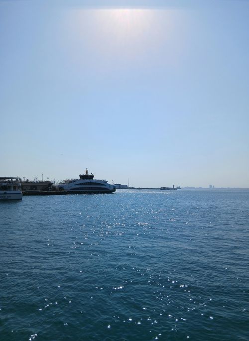Free A calm day at the harbor with boats docked and city skyline far in the distance. Stock Photo