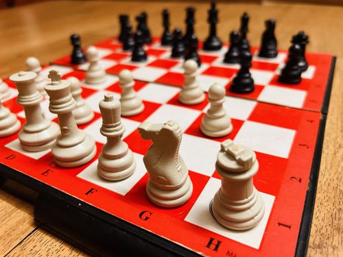 Free Close-up view of a red chessboard with white and black pieces ready for a game. Stock Photo