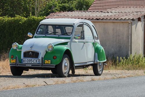 Free Classic green and white Citroën 2CV parked roadside in rural France, showcasing vintage style. Stock Photo