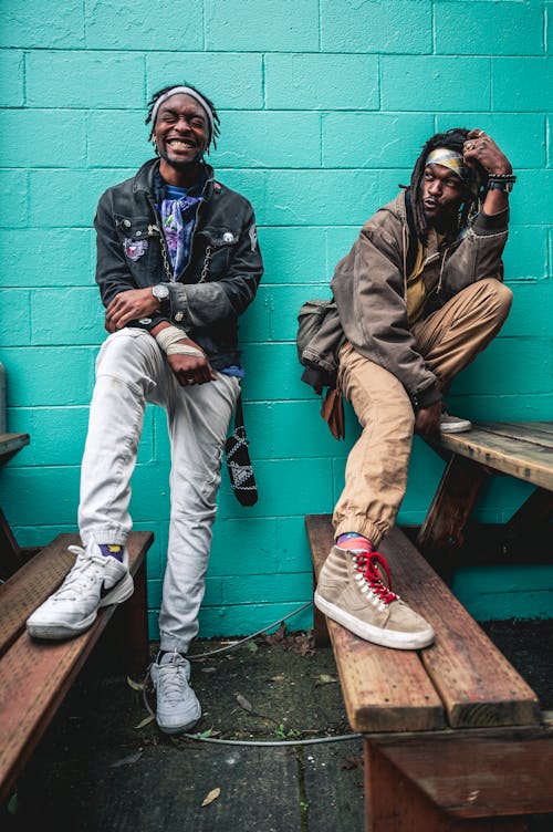 Cheerful black men leaning on bright wall · Free Stock Photo