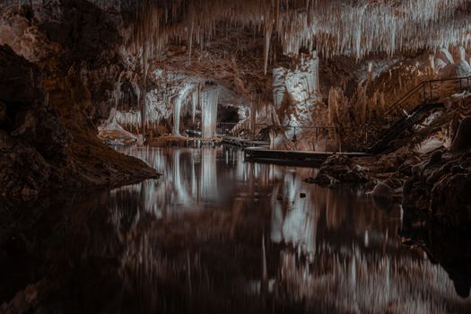 Explore the stunning formations in a limestone cave with reflective waters in Australia.