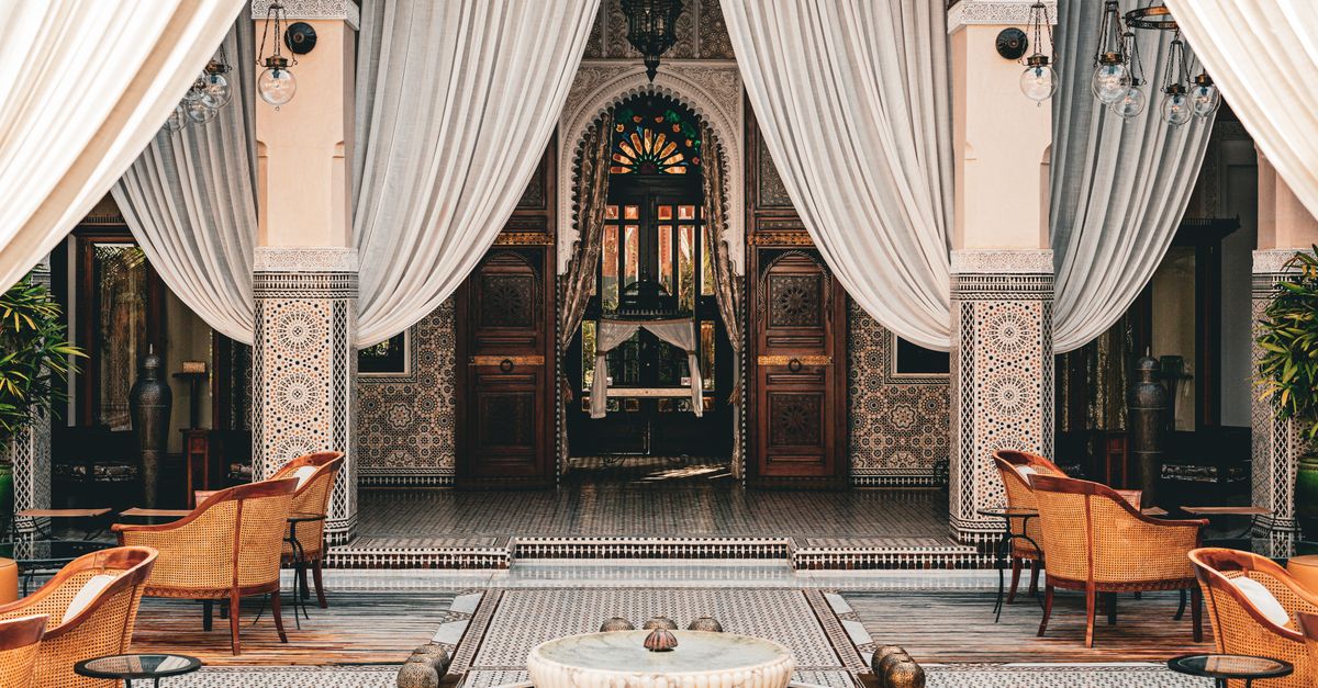 The tiled courtyard of a Marrakech riad, with drapes and a fountain
