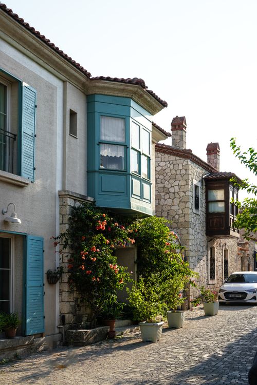 Free Picturesque street view in İzmir showcasing traditional Aegean architecture with vibrant greenery. Stock Photo
