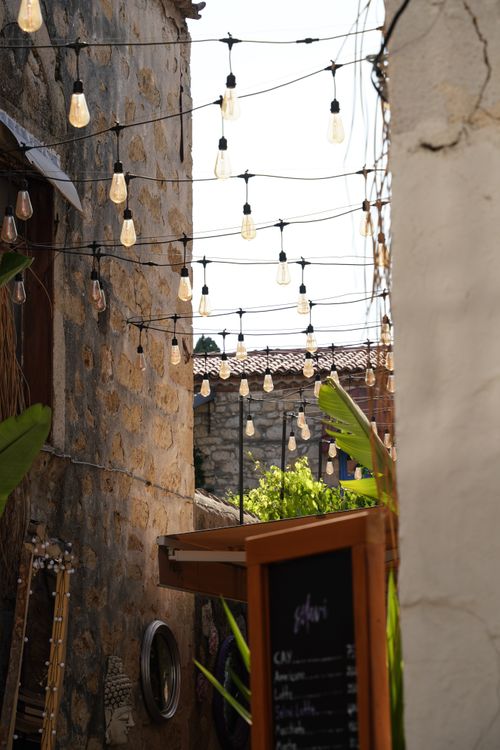 Free Quaint stone alleyway with string lights in İzmir, capturing a serene daytime ambiance. Stock Photo
