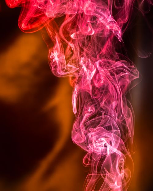 Free Intricate curls of vibrant red and orange smoke create a mesmerizing abstract design on a dark background. Stock Photo