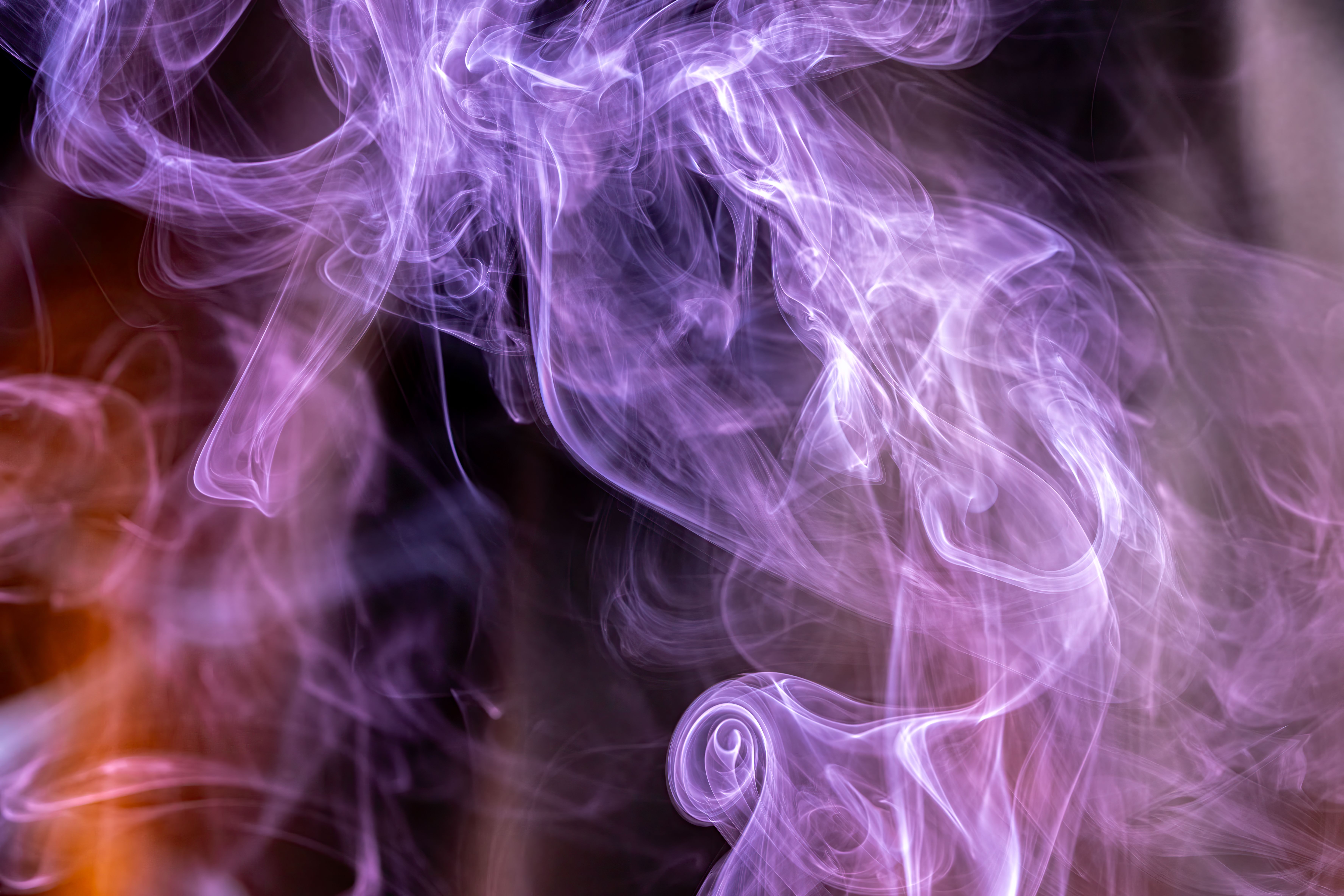 Fotomural Fascinantes remolinos de humo púrpura crean patrones abstractos sobre un fondo oscuro.