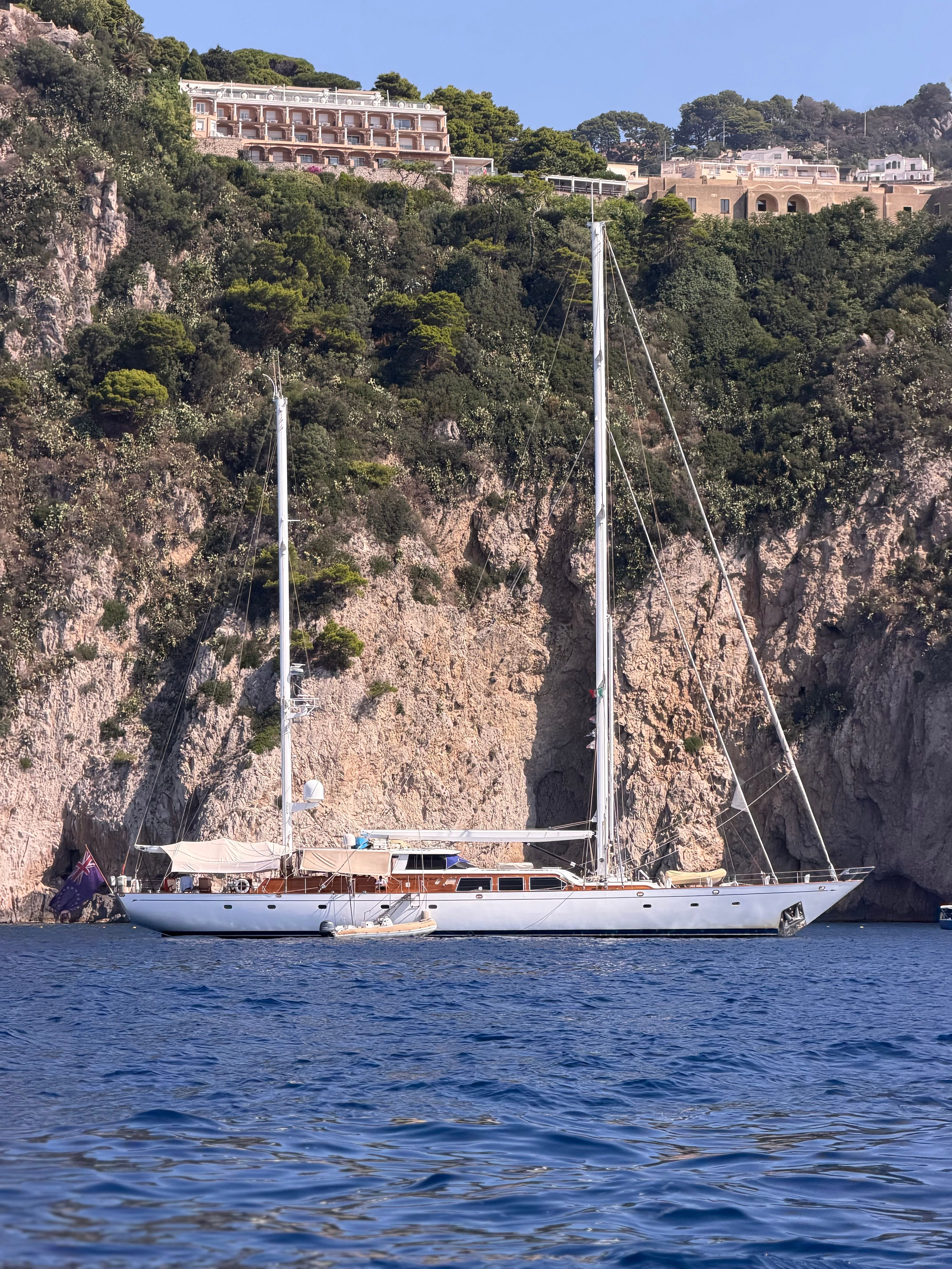 A pristine yacht anchored near the stunning cliffs and villas of Capri, Italy. Perfect travel escape.