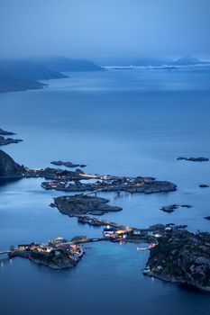 Captivating aerial view of Lofoten Islands, Norway at twilight. Serene fjords and distant mountains create a magical landscape.