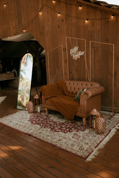 Free A charming rustic seating area with a leather sofa and detailed decor, ideal for cozy gatherings. Stock Photo
