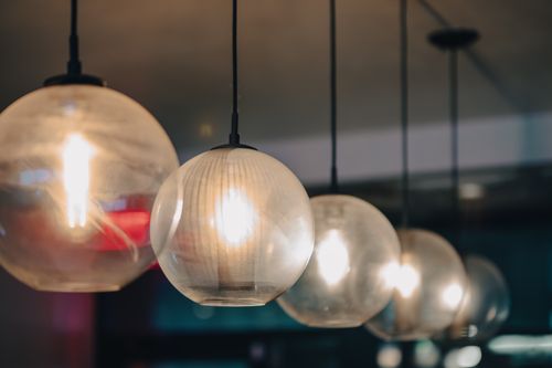 Free Elegant round pendant lights add a warm glow to a New York restaurant interior. Stock Photo