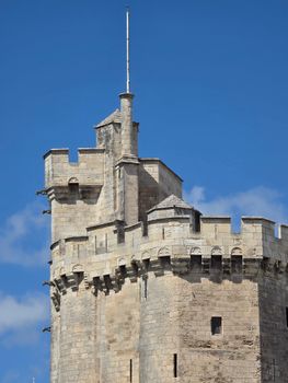 A close-up view of a historic stone tower under a clear blue sky, showcasing medieval architecture.