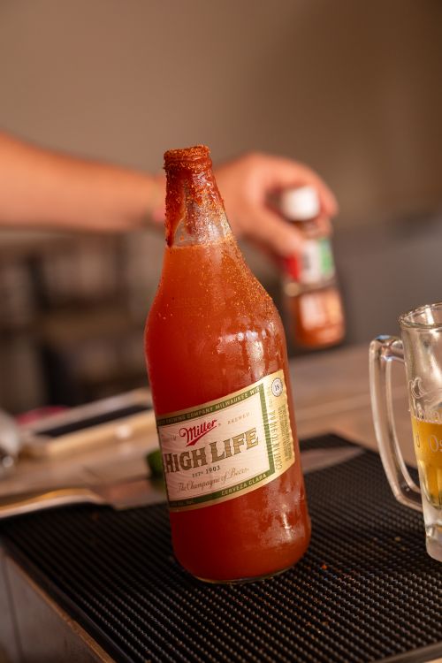 Free A flavorful beer michelada in a glass bottle with chili rim, captured indoors. Stock Photo
